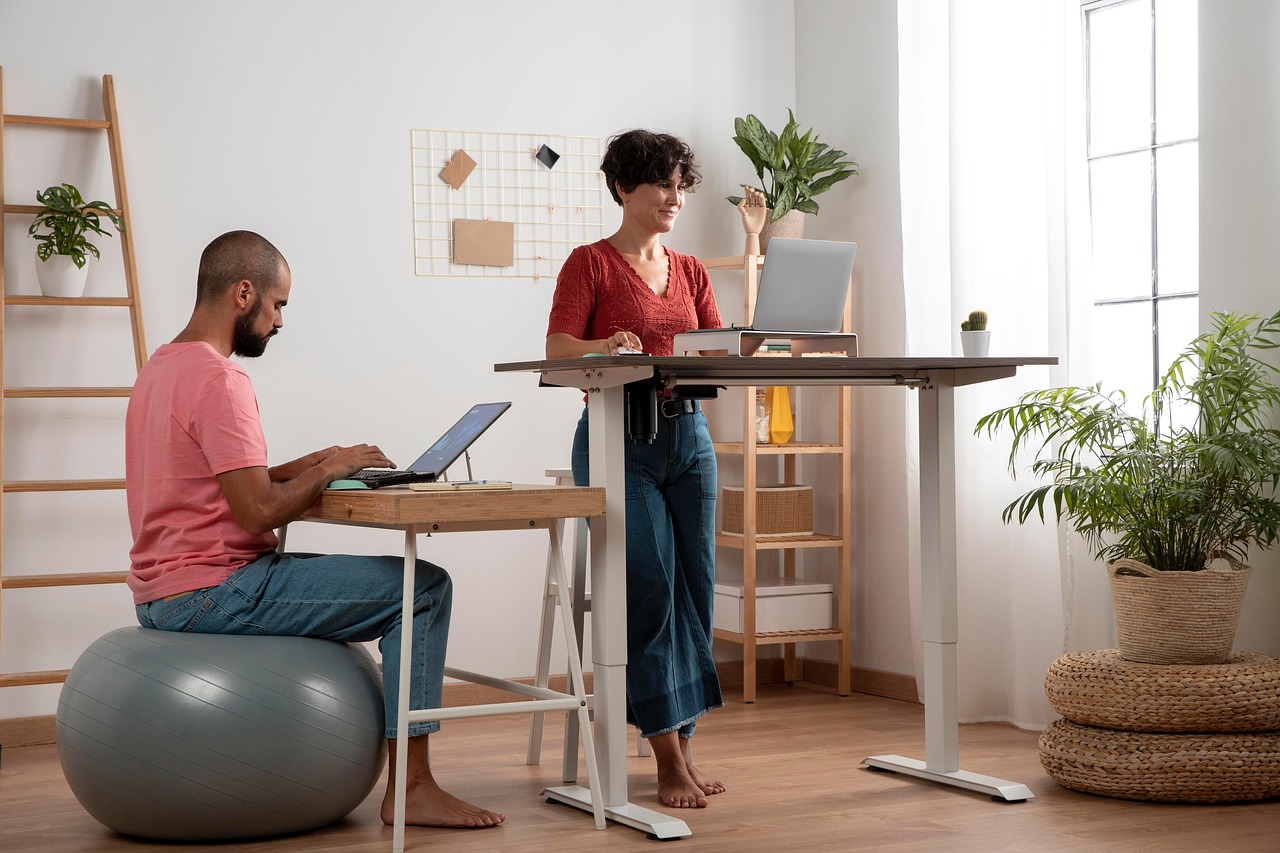 Couple working at adjustable standing desk and ergonomic home office setup